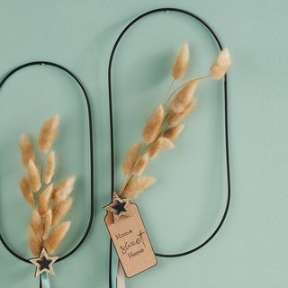 Schwarzer ovaler Metallring mit Trockenblumen