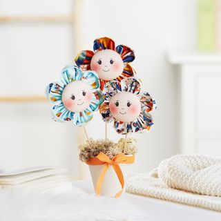 Fabric flowers with a face in a pot